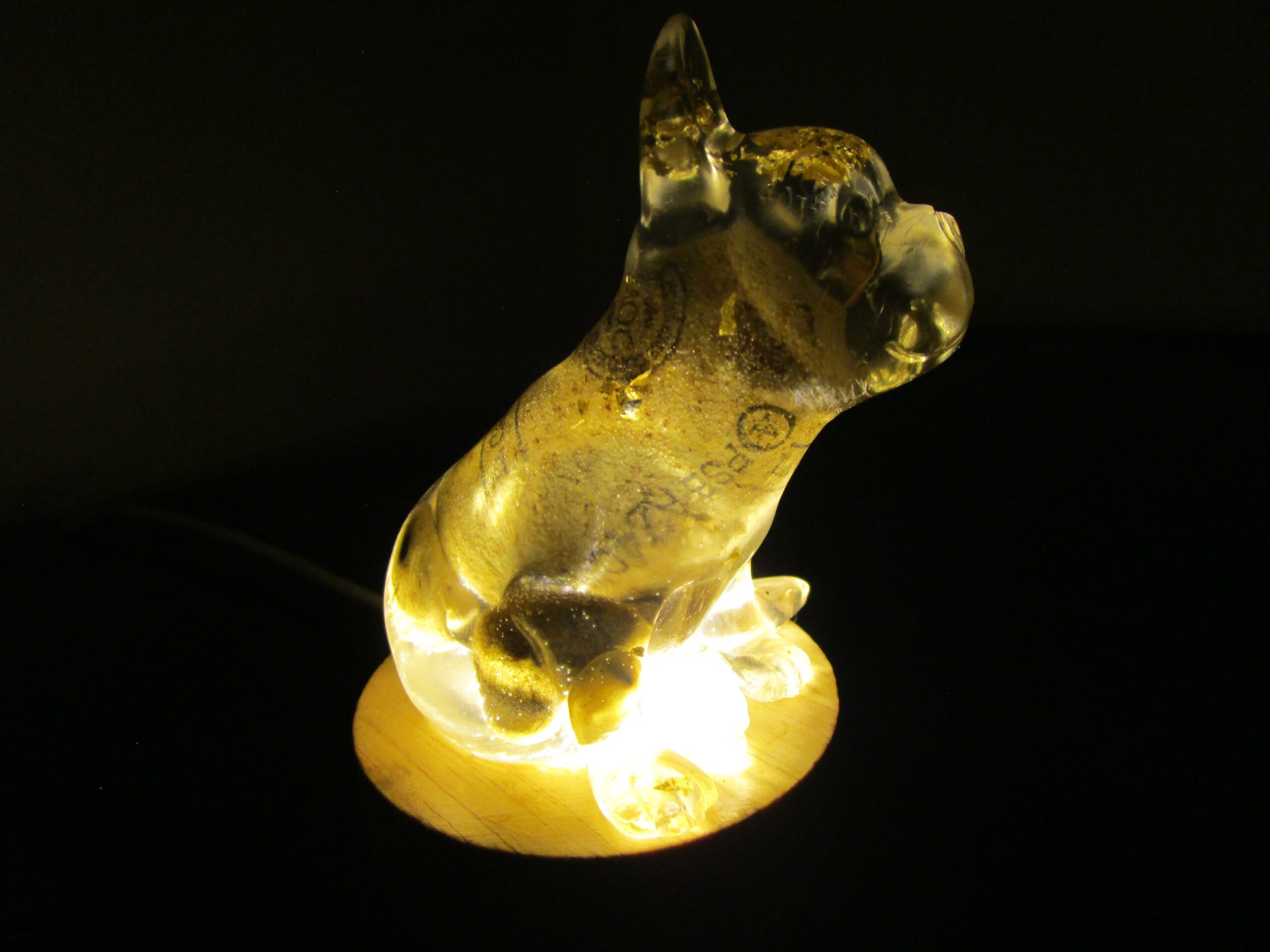 Bouledogue Tonneau Un Trésor Lumineux et Artisanal Laissez-vous charmer par "Bouledogue Tonneau", une sculpture lumineuse unique qui allie l'élégance à l'originalité. Cette pièce d'exception est façonnée à la main en résine, incrustée de feuilles d'or, de pierres naturelles et d'un bouchon de vin recyclé. Elle illumine votre intérieur d'une lumière douce et d'une touche de magie. Un Design Unique et Précieux, Fruit d'une Création Artisanale Chaque "Bouledogue Tonneau" est une œuvre d'art unique, sculptée avec passion et créativité. La résine transparente révèle les inclusions précieuses : des feuilles d'or scintillantes, des pierres naturelles aux couleurs douces et un bouchon de vin recyclé, symbole d'une démarche éco-responsable. Le design original de cette sculpture apporte une touche d'humour et de raffinement à votre décoration. Une Lumière Douce et Enchanteuse, Créant une Ambiance Magique La lumière émanant du socle illumine la résine et fait scintiller les inclusions, créant un spectacle visuel captivant. Ce bouledogue lumineux est idéal pour créer une ambiance chaleureuse et accueillante. Il apporte une touche de magie et d'originalité à votre intérieur, transformant votre espace en un lieu enchanteur. Un Objet Décoratif Unique et Précieux, Témoin d'un Engagement "Bouledogue Tonneau" est bien plus qu'une simple sculpture. C'est une pièce de collection qui témoigne d'un savoir-faire artisanal et d'un engagement pour l'environnement. Son design unique et ses matériaux précieux en font un objet décoratif exceptionnel. Caractéristiques Matériaux : Résine, feuilles d'or, pierres naturelles, bouchon de vin recyclé, socle lumineux Fabrication : Artisanale, chaque pièce est unique Design : Original et précieux, s'adapte à tous les styles d'intérieur Lumière : Douce et chaleureuse, crée une ambiance enchanteresse Conseils d'Entretien Pour préserver la beauté de votre "Bouledogue Tonneau", nous vous recommandons de le nettoyer délicatement avec un chiffon doux. Évitez l'exposition prolongée au soleil et aux sources de chaleur intense. Laissez-vous séduire par le charme et l'éclat de "Bouledogue Tonneau". Il est une création unique qui apportera une touche de magie et de lumière à votre intérieur.