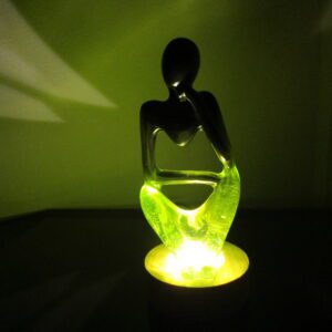 Penseur Songe : Une Fenêtre sur l'Imaginaire Laissez-vous transporter dans un monde de rêves et de contemplation avec notre sculpture "Penseur Songe". Cette pièce unique, façonnée à la main, est une véritable invitation à l'évasion. Elle allie l'élégance de la résine vert forêt et noire à la douce lumière d'un socle en bois, créant une atmosphère magique et apaisante. Un Design Onirique et Inspirant Chaque détail de cette sculpture a été pensé pour stimuler l'imagination. La résine vert forêt et noire, avec ses nuances subtiles, évoque les profondeurs de la pensée. La silhouette du penseur, plongé dans ses réflexions, invite à la méditation. Le socle en bois lumineux ajoute une dimension onirique, comme si la sculpture flottait dans un monde de rêves. Une Lumière Douce et Apaisante La lumière émanant du socle crée une ambiance douce et apaisante, propice à la relaxation et à la rêverie. Elle met en valeur les formes de la sculpture et crée un jeu de lumière fascinant. Cette sculpture est idéale pour créer un espace de détente et de réflexion, un refuge pour l'esprit. Un Objet Décoratif Unique et Original "Penseur Songe" est bien plus qu'une simple sculpture. C'est une véritable œuvre d'art qui apporte une touche d'originalité et de poésie à votre intérieur. Son design unique et sa lumière apaisante en font un objet décoratif qui ne manquera pas de susciter l'admiration. Caractéristiques Matériaux : Résine vert forêt et noire, bois lumineux Fabrication : Artisanale, chaque pièce est unique Design : Onirique et inspirant, s'adapte à tous les styles d'intérieur Lumière : Douce et apaisante, crée une ambiance de rêverie Conseils d'Entretien Pour préserver la beauté de votre sculpture, nous vous recommandons de la nettoyer délicatement avec un chiffon doux. Évitez l'exposition prolongée au soleil et aux sources de chaleur intense. Laissez-vous emporter par la magie de "Penseur Songe". Cette sculpture est une invitation à la rêverie et à la contemplation, un véritable voyage intérieur.