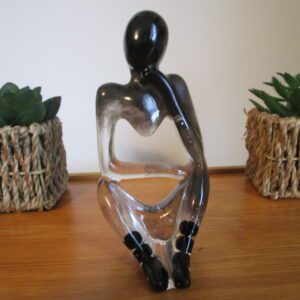 Gardien de la sérénité Tout d'abord, l'artisan vous invite à découvrir "Gardien de la Sérénité". Ensuite, il façonne à la main cette sculpture unique avec passion. Par ailleurs, il utilise de la résine transparente, comme un écrin pour la lumière. De plus, il crée une silhouette humaine, symbole de la sérénité. Ainsi, il donne vie à un gardien mystérieux, protecteur de l'harmonie. Enfin, il incruste des fragments d'argent et des perles de tourmaline noire, symboles de protection et d'ancrage.