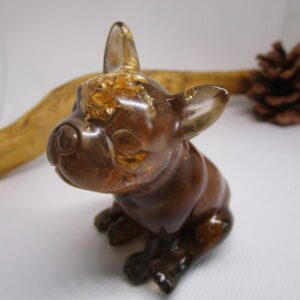 Figurine artisanale "Bouledogue Deluxe" un bouledogue français en résine transparente avec des feuilles d'or et des pierres. Un bouchon de champagne est intégré à la figurine. La figurine est une pièce unique, faite à la main. Elle combine différents matériaux : résine, feuilles d'or, pierres et un bouchon de champagne. Elle est idéale pour décorer votre intérieur ou offrir en cadeau.