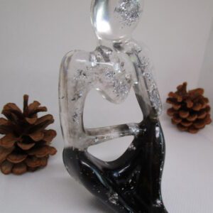 Le Penseur Élégant Une Ode à la Réflexion, Capturée en Résine et Argent Introduction : L'Éveil de la Pensée D'abord, laissez-vous séduire par cette sculpture unique. Elle fige l'instant de la réflexion. Ensuite, l'artiste donne vie au "Penseur Élégant". Cette œuvre d'art incarne la beauté de l'esprit. De plus, chaque détail est façonné avec soin. Ainsi, cette création est le fruit d'un savoir-faire artisanal. La Résine : Un Jeu de Transparence et de Profondeur L'artiste privilégie la résine pour sa clarté. En effet, ce matériau danse avec la lumière. Par ailleurs, il crée un contraste saisissant. La résine noire évoque le mystère. En revanche, la résine transparente symbolise la lucidité. L'Argent : Un Éclat Précieux et Lumineux Des éclats d'argent illuminent la sculpture. Ils apportent une touche de raffinement. L'argent symbolise la pureté et la sagesse. De surcroît, il représente la valeur de la pensée. Ces inclusions argentées rendent chaque pièce exclusive. Elles captent la lumière et scintillent délicatement. Un Design Épuré : L'Harmonie des Formes et des Lignes Le design de la sculpture est minimaliste. Il met en lumière la silhouette du penseur. Les lignes sont fluides et gracieuses. Elles invitent à la méditation. La forme épurée favorise la concentration. Elle permet de se recentrer sur l'essentiel. Une Création Artisanale : L'Expression d'une Passion L'artiste façonne chaque sculpture à la main. Il y insuffle une part de son âme. Ce travail artisanal garantit l'authenticité. Vous acquérez une œuvre d'art véritable. Cette sculpture reflète une passion sincère. Un Objet de Décoration : Une Source d'Inspiration Cette sculpture trouve sa place dans votre intérieur. Elle apporte une atmosphère sereine et élégante. Disposez-la sur un bureau ou une étagère. Elle devient un élément central de votre décoration. Elle suscite la curiosité et l'émerveillement. Elle encourage à la réflexion et à la contemplation. Conclusion : Un Investissement Artistique et Émotionnel "Le Penseur Élégant" est bien plus qu'une simple sculpture. C'est une pièce de collection et un investissement durable. Elle traverse le temps et les tendances. Elle conserve sa valeur et sa beauté. Offrez-vous cette œuvre d'art unique. Elle témoigne de votre goût pour l'art et l'originalité. Vous possédez un fragment de l'âme de l'artiste.