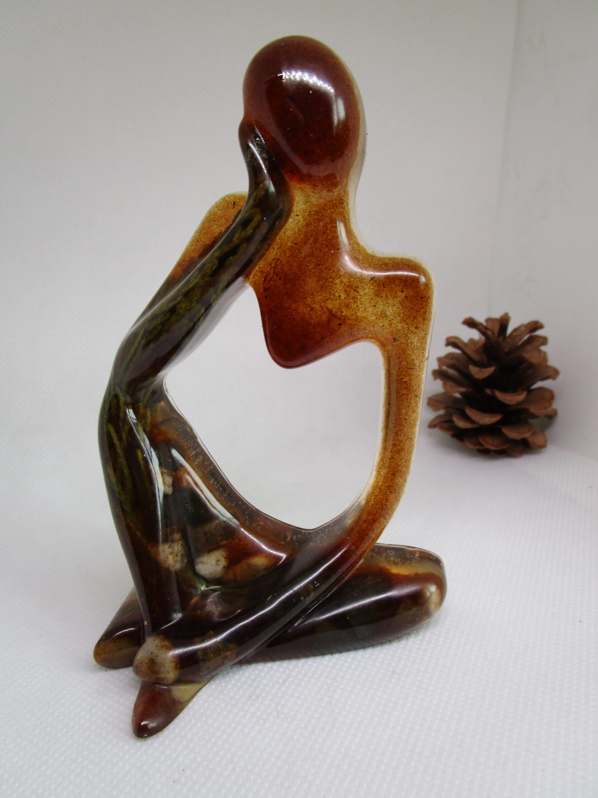 Le Penseur Rustique en résine avec tige de sapinette, pierres naturelles et sciure de bois. Style rustique, couleurs naturelles.