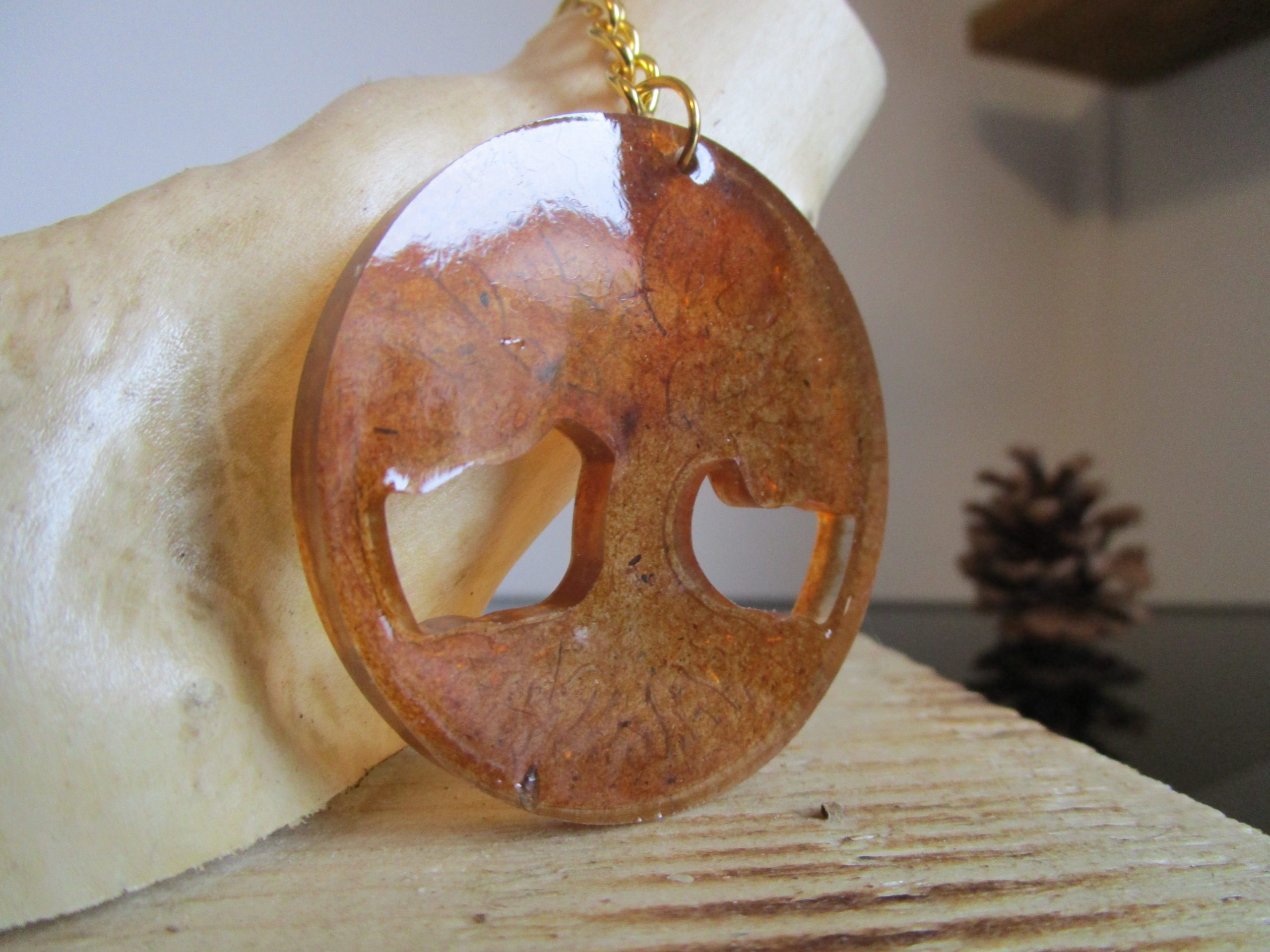 "Ce porte-clés ovale est un hommage à la nature. La sciure de bois, matière naturelle et chaleureuse, lui confère un aspect authentique. Le motif d'arbre de vie, symbole de force et de longévité, renforce cette connexion avec la nature."