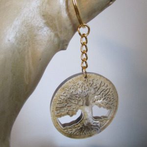 Le Souffle de la Forêt Emportez un morceau de nature avec vous grâce à ce porte-clés original. Réalisé à partir de résine et de sciure de bois recyclée, il arbore un magnifique motif d'arbre de vie. Chaque pièce est unique, avec ses propres nuances et textures. Un accessoire écologique et plein de charme."
