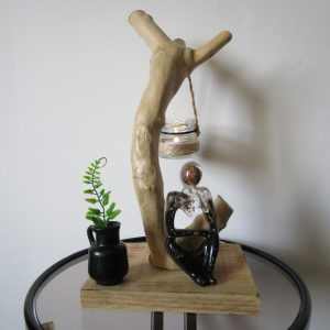 "Ce Penseur unique ne se contente pas de captiver le regard par sa silhouette en résine incrustée de feuilles d'or et sa balle de mousquet du XVIIe siècle. Il est également mis en valeur par un socle en bois naturel, provenant d'une branche d'arbre soigneusement sélectionnée. Chaque pièce de bois est unique, avec ses propres veines et sa texture naturelle, ajoutant une dimension organique et chaleureuse à l'ensemble."