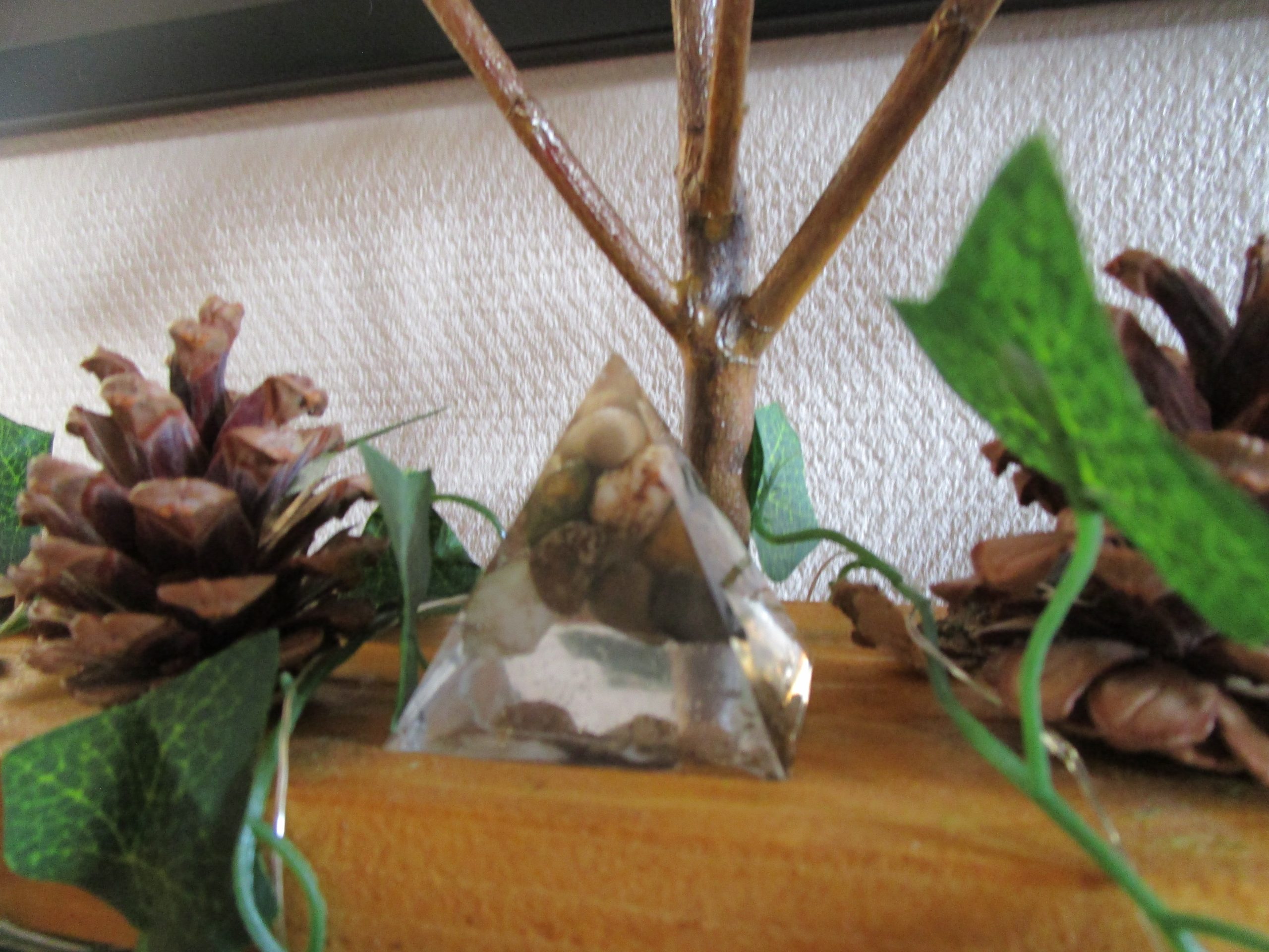 "Une pyramide de résine, façonnée à la main, emprisonne la beauté brute des pierres naturelles. Chaque pierre, choisie avec soin, raconte une histoire millénaire, figée dans la transparence cristalline de la résine. Une œuvre unique, où l'art et la nature se rencontrent."
