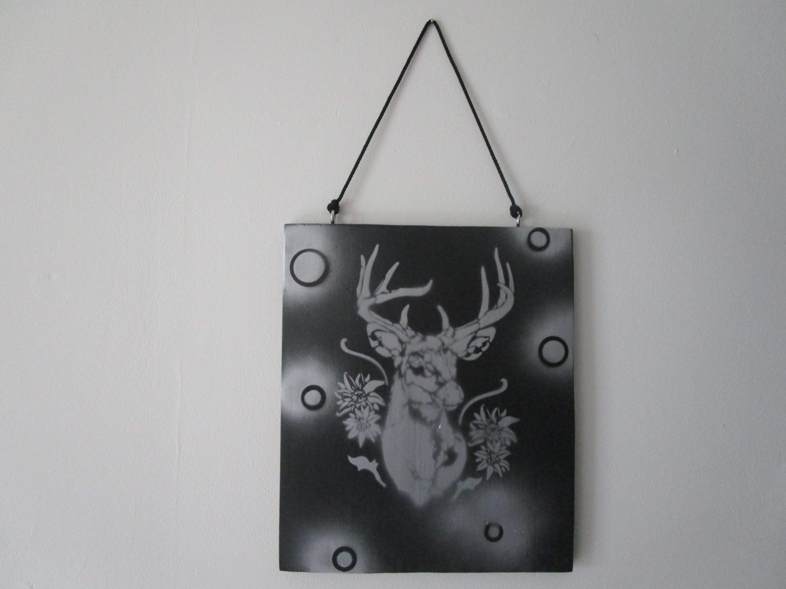 "Peinture sur bois recyclé 'Fleurs de Bois' : cerf gris stylisé avec motifs floraux et géométriques sur fond noir. Création artisanale unique, décoration murale rustique et élégante."