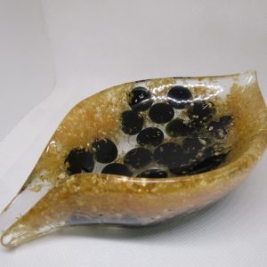 Éclats d'Obsidienne Dorée "Image d'une création artisanale en forme de feuille, réalisée en résine transparente avec des inclusions de copeaux de bois dorés et des pierres plates noires d'obsidienne, vue en perspective sur un fond clair."