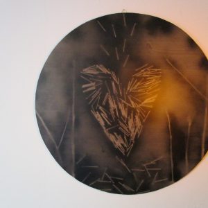 Cœur d'Énigme : Un Tableau qui Défie les Attentes Imagine un cercle de bois, né d'un ancien lit, qui renaît en une œuvre d'art intrigante. C'est "Cœur d'Énigme", un tableau qui mélange l'ancien et le moderne, le doux et le dur, pour créer une pièce de décoration unique. Le Support : Un Cercle de Bois Chargé d'Histoire Tout d'abord, un cercle de bois, découpé dans un ancien lit, sert de toile à cette création. Ce bois, témoin d'une vie passée, apporte une dimension historique et chaleureuse à l'œuvre. Le Cœur : Une Explosion de Clous Ensuite, un cœur, symbole universel de l'amour, est réinventé avec des clous. Ces clous, disposés de manière aléatoire, créent une texture surprenante et un contraste saisissant avec la douceur de la forme du cœur. L'Effet 3D : Une Illusion Captivante Par ailleurs, la peinture en spray, appliquée avec une technique experte, crée un effet 3D saisissant. Le cœur semble ainsi jaillir du support, captant le regard et suscitant l'émotion. L'Empreinte : Un Secret Caché De plus, derrière le tableau, se cache l'empreinte du pouce de l'artiste. Cette signature discrète, tel un sceau, confère à l'œuvre une authenticité et une valeur uniques. "Cœur d'Énigme" : Une Œuvre d'Art Unique et Émouvante En somme, "Cœur d'Énigme" est bien plus qu'un simple tableau. C'est une œuvre d'art unique, chargée d'histoire et d'émotion, qui apportera une touche d'originalité et de mystère à votre intérieur.