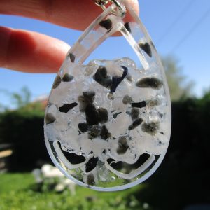 Passeur d'Énergie Porte-Clé Magique : Tes Petites Pierres de Chance Imagine un petit trésor à accrocher partout ! C'est un porte-clé en forme de goutte d'eau, tout transparent, et dedans, il y a plein de petites pierres de couleurs différentes : du noir et du blanc. On dirait des petits cailloux magiques qui brillent. Un Look Original et Cool Ce porte-clé est super pour décorer ton sac, tes clés, ta trousse... Il donne un style unique et amusant. Les petites pierres qui bougent à l'intérieur sont rigolotes à regarder. C'est un peu comme avoir un mini aquarium de pierres toujours avec toi ! Tes Petits Gardiens de Poche Ces petites pierres ne sont pas que jolies. Certaines personnes pensent qu'elles peuvent apporter de bonnes choses. Le noir et le blanc, c'est un peu comme le jour et la nuit, l'équilibre. Peut-être que ces petites pierres t'aideront à te sentir bien dans ta journée ! Une Super Idée Cadeau Si tu veux faire un petit cadeau sympa à un copain ou une copine, ce porte-clé est une bonne idée. Il est original, il est mignon, et il peut porter chance ! C'est un petit geste qui fait plaisir. Pourquoi tu vas adorer ce porte-clé : Il est léger et facile à accrocher partout. Les petites pierres à l'intérieur sont amusantes. Il donne un style unique à tes affaires. C'est une idée cadeau originale et abordable. Alors, prêt à emporter partout avec toi ton petit "Passeur d'Énergie" ?