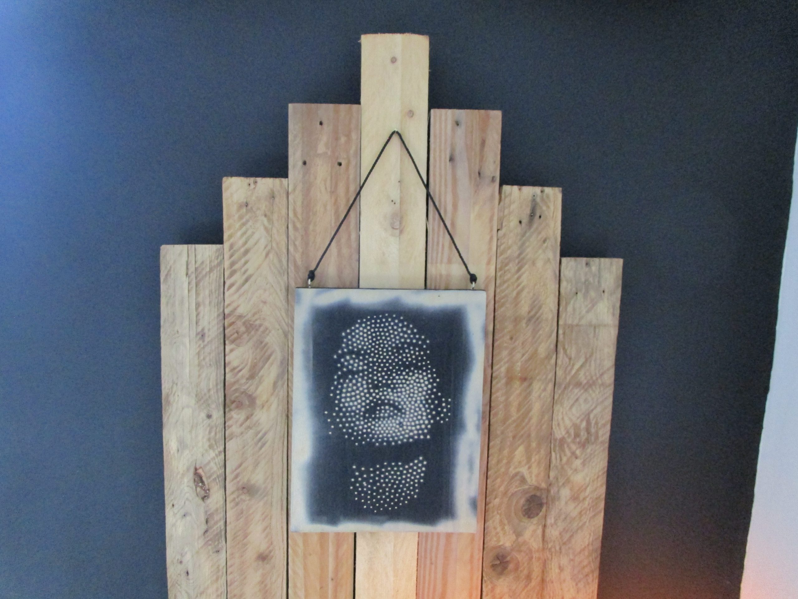 L'Écho du Silence D'une planche de bois recyclé renaît un visage féminin, esquissé par une myriade de points délicats. La main de l'artiste danse, déposant avec précision chaque touche de peinture, tandis que la bombe aérosol murmure des ombres douces et des lumières subtiles autour de cette apparition. Le pointillisme, tel un souffle retenu, construit les traits, les émotions, le mystère qui émane de cette figure silencieuse. Les imperfections du bois, loin d'être des défauts, racontent le passé du matériau, offrant une patine unique à ce portrait contemporain. "L'Écho du Silence" n'est pas seulement une image ; c'est une méditation visuelle, une rencontre entre la fragilité d'un visage et la robustesse d'un support réinventé, une invitation à écouter le langage secret de l'art et de la matière.