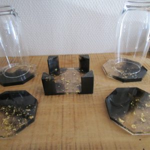 Élégance Dorée. Sublimez votre table avec cet ensemble de 4 dessous de verre en résine noire incrustée de feuilles d'or. Socle inclus pour un rangement élégant. L'artisanat au service de votre quotidien.