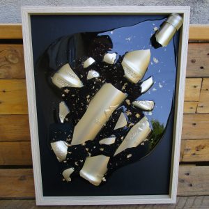 Fragment de Toi Cadre artistique fait main montrant des éclats dorés d'une bouteille dans de la résine transparente avec des incrustations de feuilles d'or, accroché sur un mur blanc.