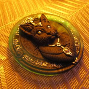 Magnet artisanal en résine représentant un chat noir orné de bijoux argentés sur un disque bleu translucide gravé de symboles ésotériques.